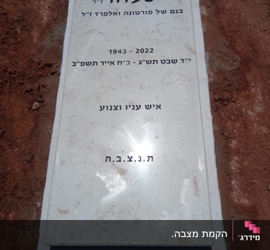 מצבה עם כיתוב בעברית על אדמה